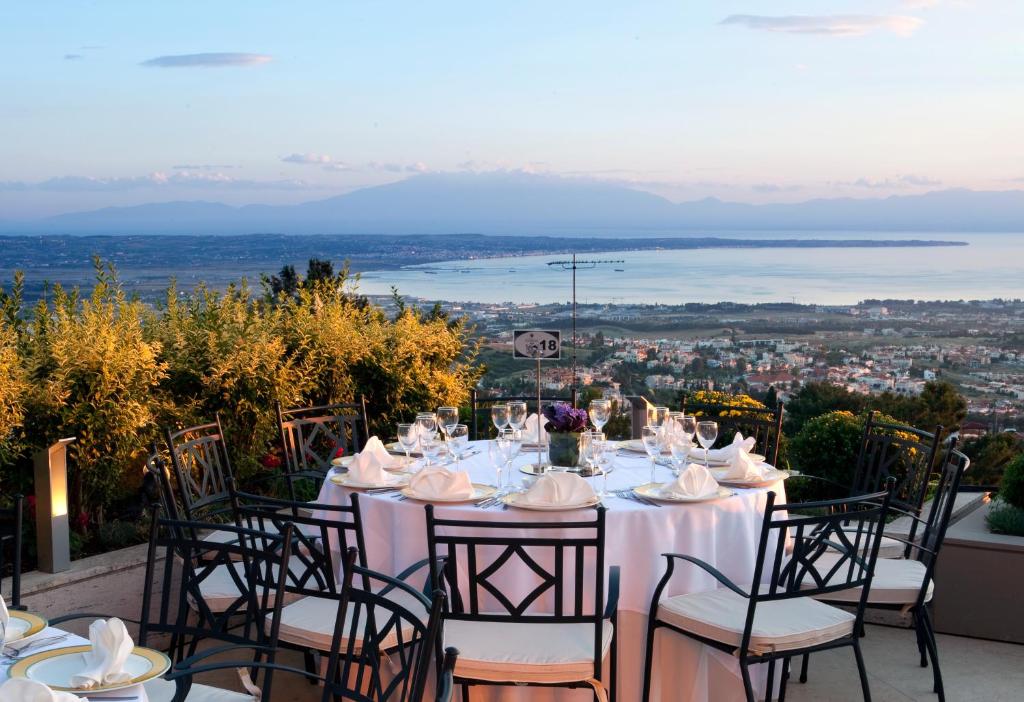 a table with white table cloths and chairs with a view at Hotel Panorama in Thessaloniki