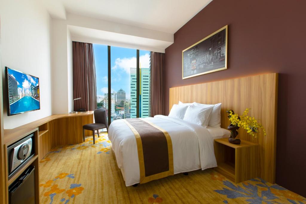 a hotel room with a bed and a large window at Bay Hotel Ho Chi Minh in Ho Chi Minh City