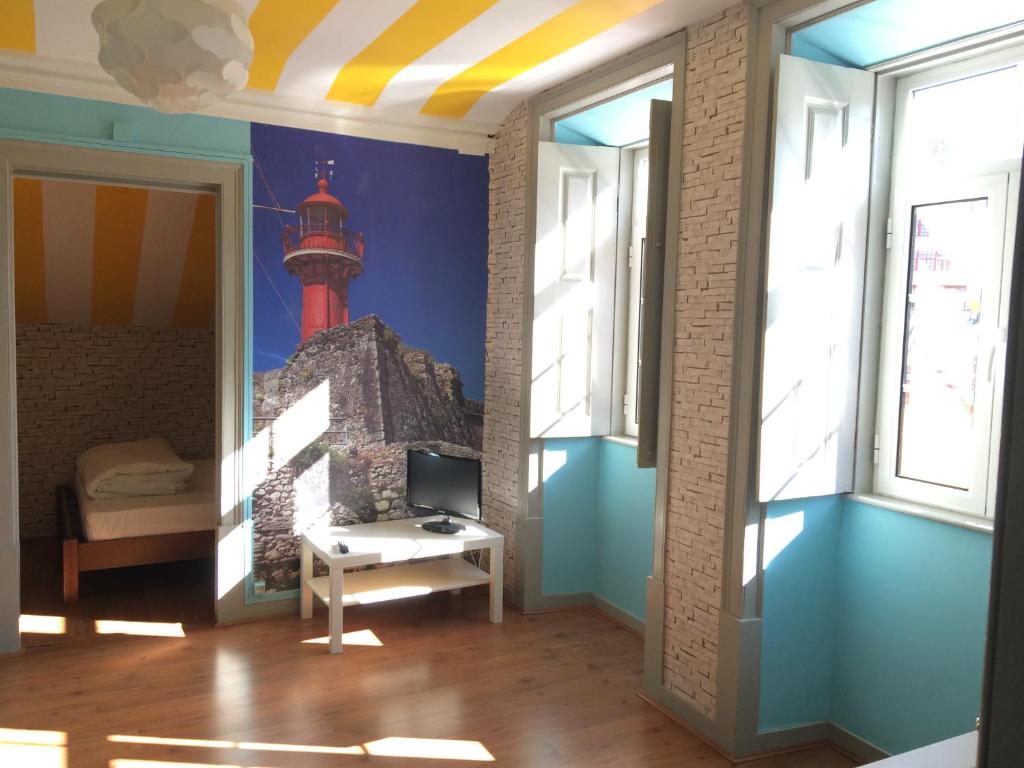 a room with a lighthouse mural on the wall at Meeting Hostel in Figueira da Foz