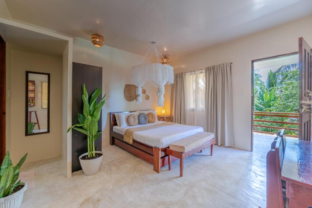 Un dormitorio con una cama y una planta en maceta. en Keking's Surf Guesthouse, en General Luna