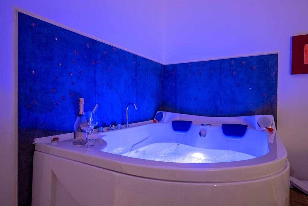 Adua Luxury Apartment في تارانتو: حوض استحمام في غرفة ذات جدار أزرق