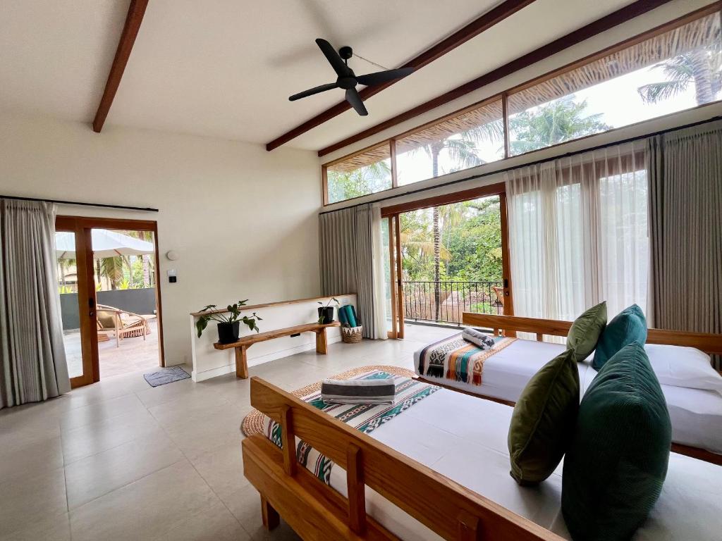 ein Schlafzimmer mit zwei Betten und einem großen Fenster in der Unterkunft Villa Luna - Gili Air in Gili Air