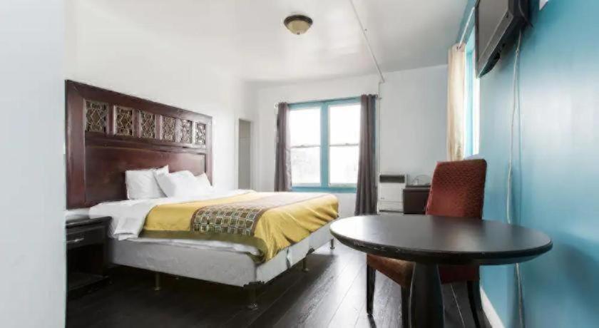 a bedroom with a bed and a desk and a table at Stuart Hotel in Los Angeles