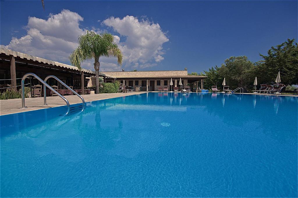 a large blue swimming pool in front of a building at Hotel Masseria Le Pajare in Presicce