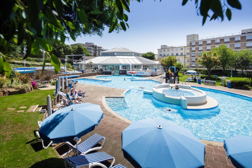 a pool with a water park with umbrellas at Merton Hotel in St. Saviour