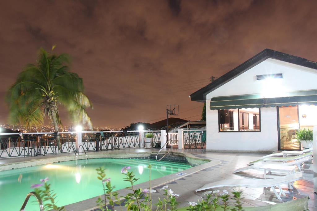 a swimming pool in front of a building at night at Hill View Hotel McCarthy Hills in Botianaw