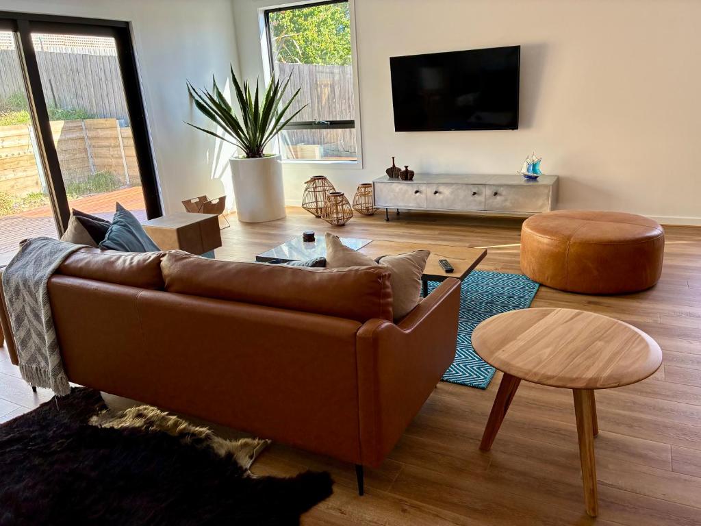 a living room with a brown couch and a table at McCrae Retreat Brand New Home in McCrae