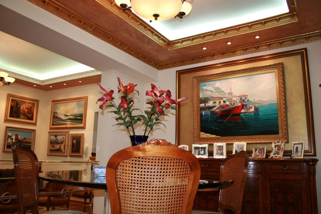 a dining room with a table and a painting of a boat at Villa Gallery in Selínia