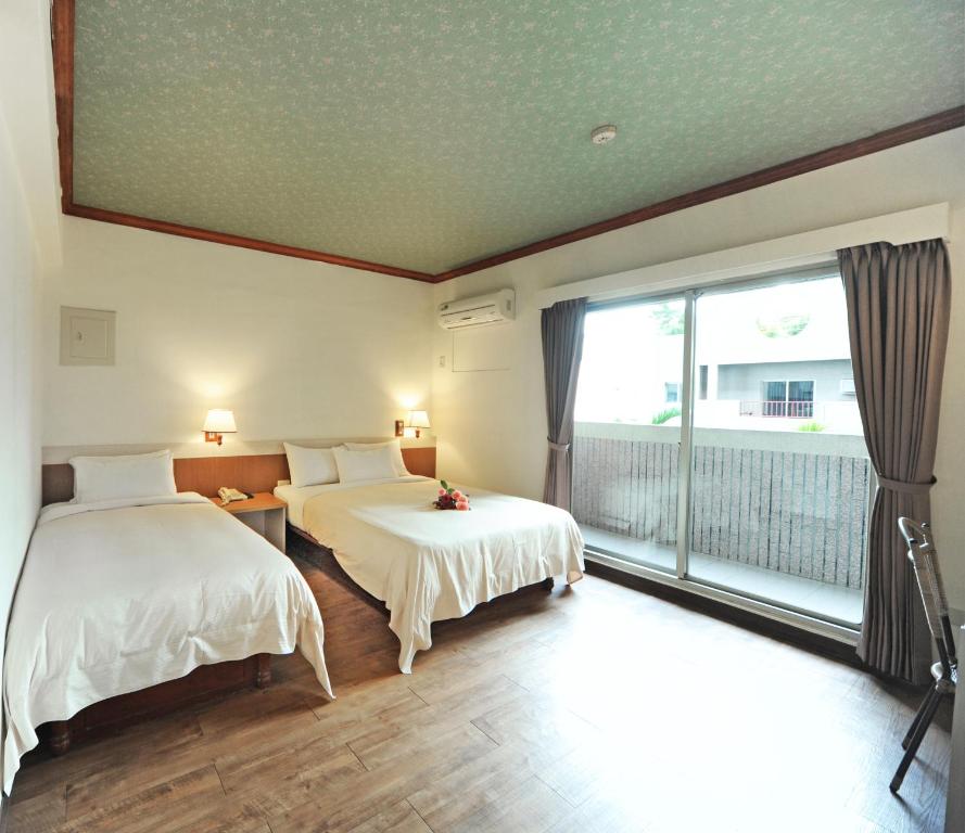 Rúm í herbergi á Kenting Holiday Hotel