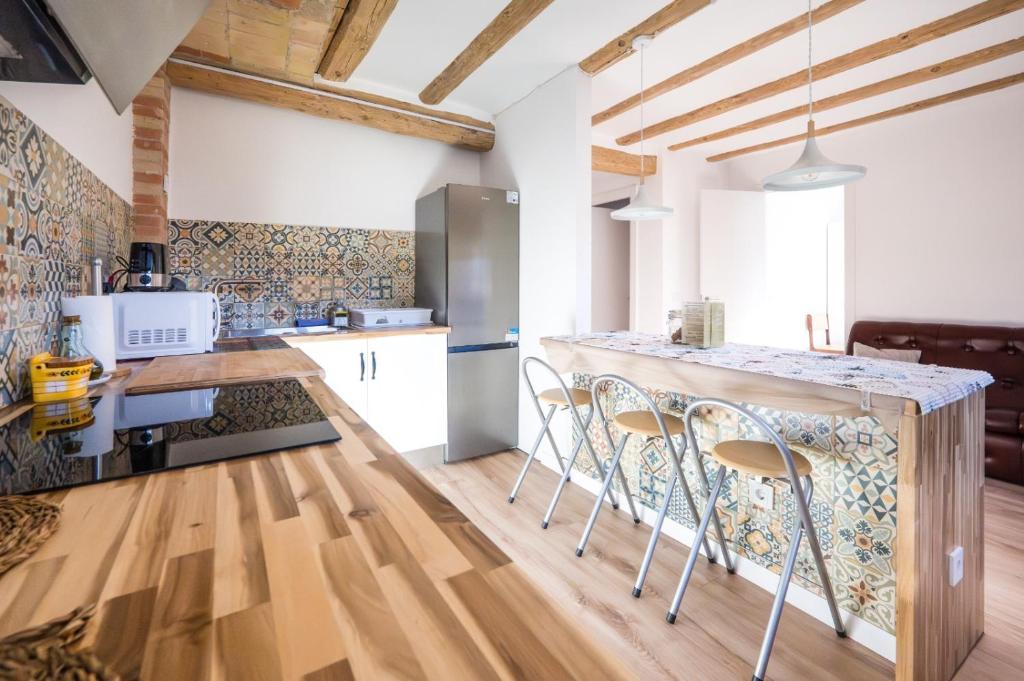 a kitchen with a counter and chairs in a room at Rural apartment La Cantonada in Guardiola de Berguedà
