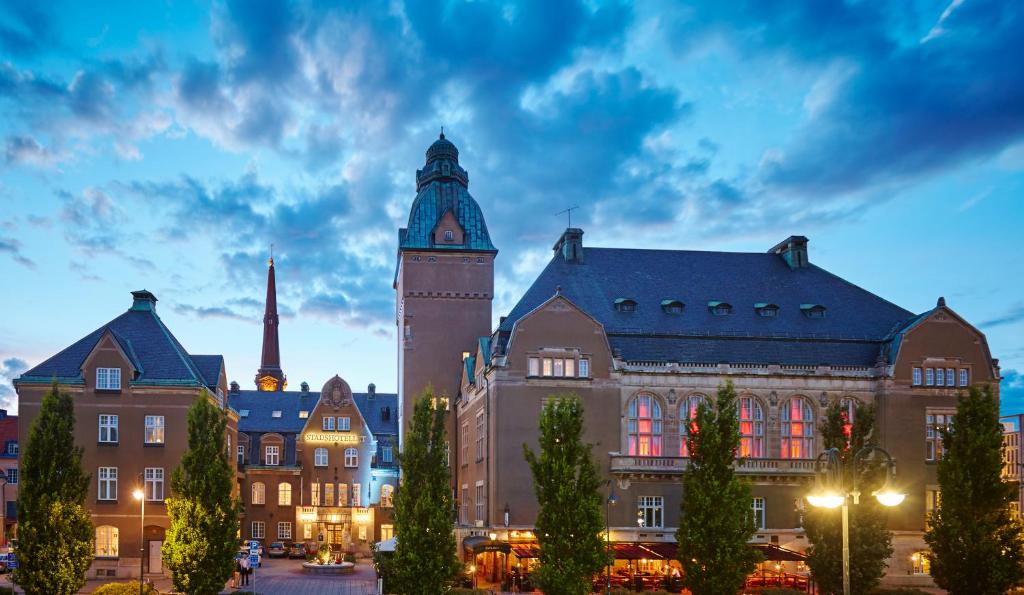 un edificio con una torre de reloj delante de él en Elite Stadshotellet Västerås, en Västerås