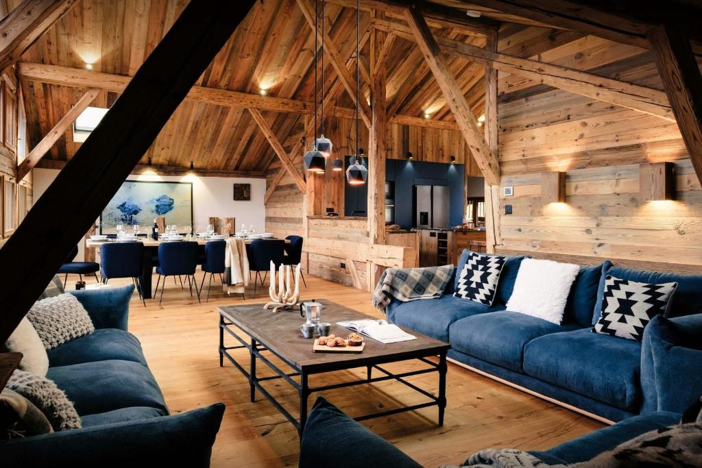 a living room with blue couches and a table at Chalet Trumont - OVO Network in Morillon