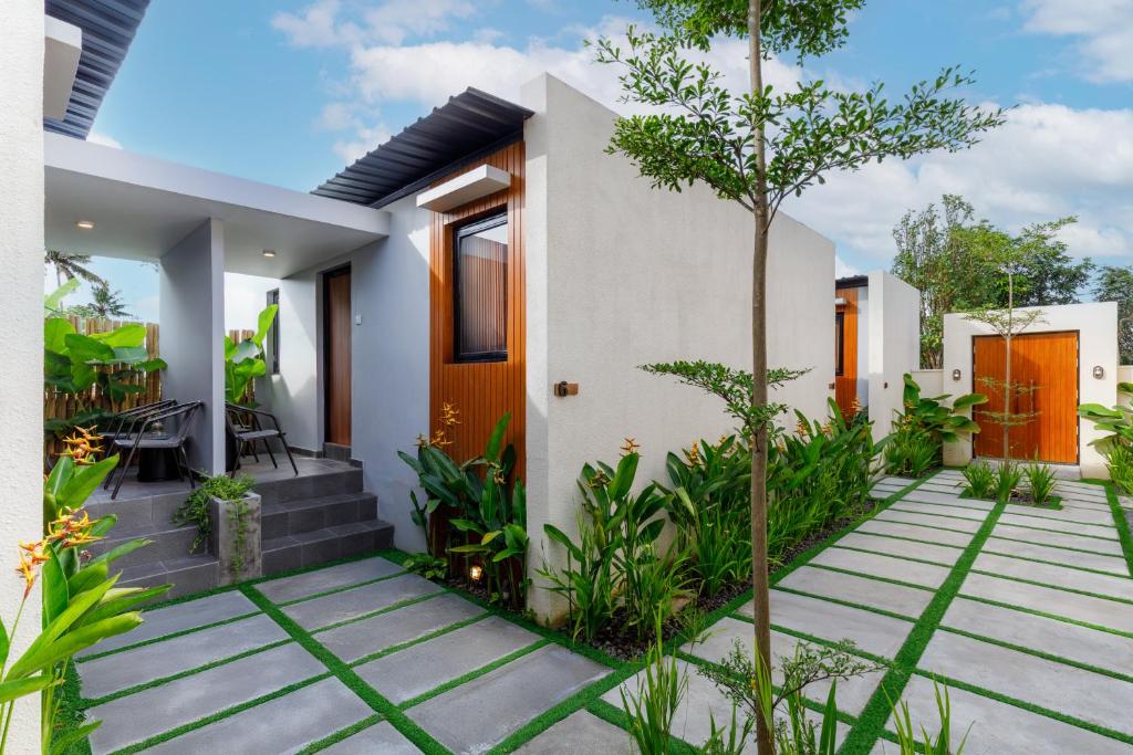 a home with a pathway leading to the front yard at Andewi Cabin in Canggu