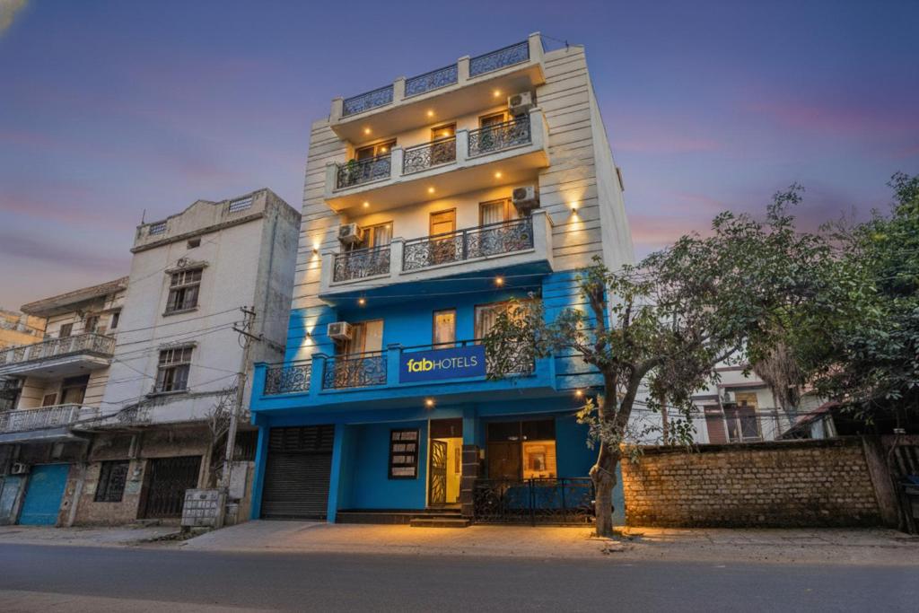 um edifício azul e branco com uma árvore em frente em Via Prime Residency em Nova Deli