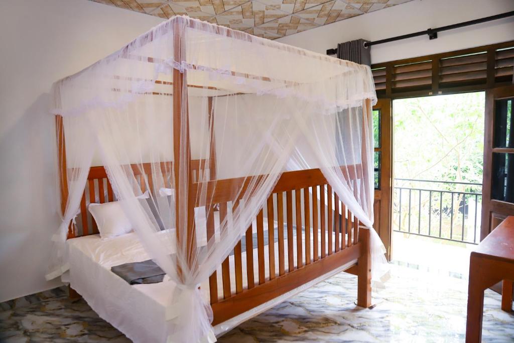 a bedroom with a crib with mosquito nets at Chatu villa in Ahangama