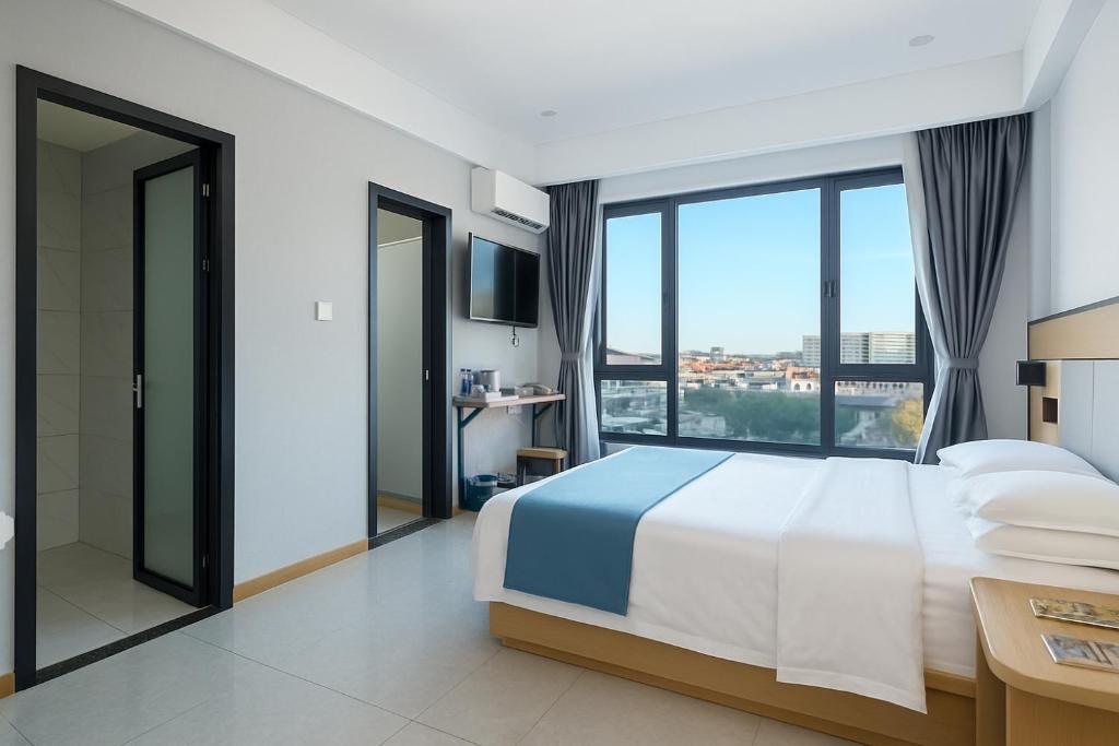 ein Schlafzimmer mit einem großen Bett und einem großen Fenster in der Unterkunft ARK HOTEL in Phnom Penh