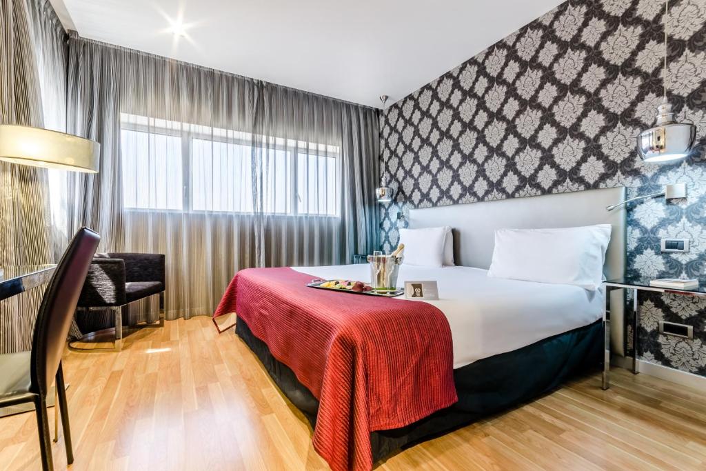 Habitación de hotel con cama con manta roja en Eurostars Executive, en Barberà del Vallès