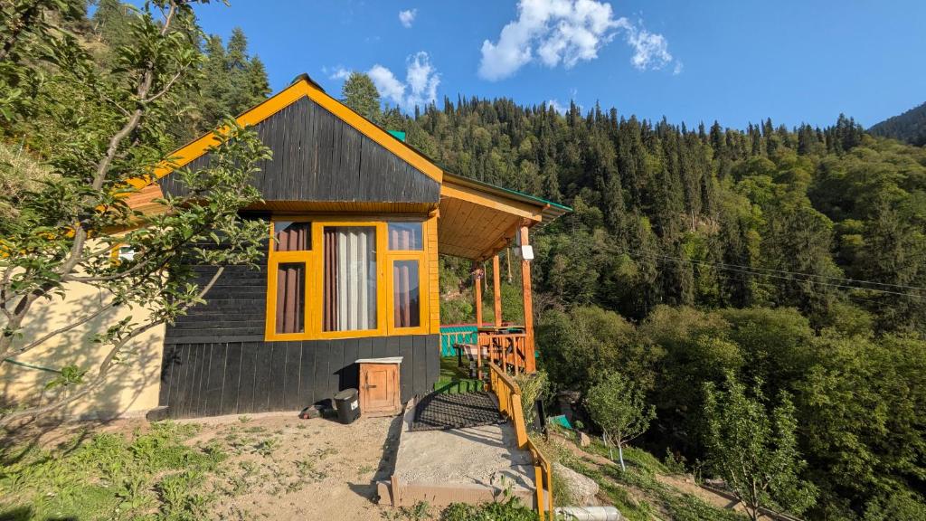 a small house in the middle of a forest at Monkstel Cottages Shangarh in Shangarh