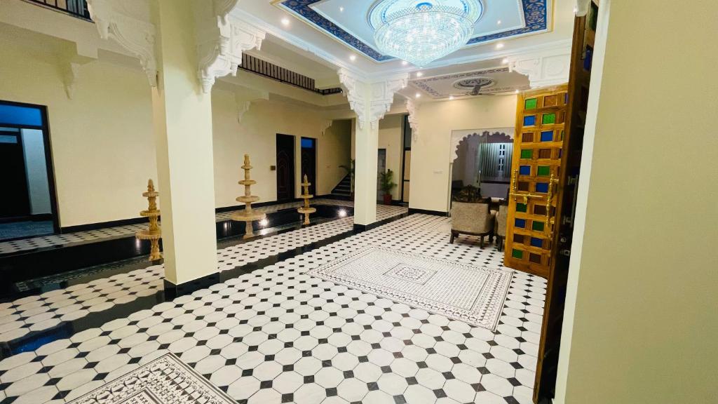 Ein Flur in einem Gebäude mit weiß-schwarz gefliestem Boden in der Unterkunft Aryavarta A Boutique Abode in Nāi