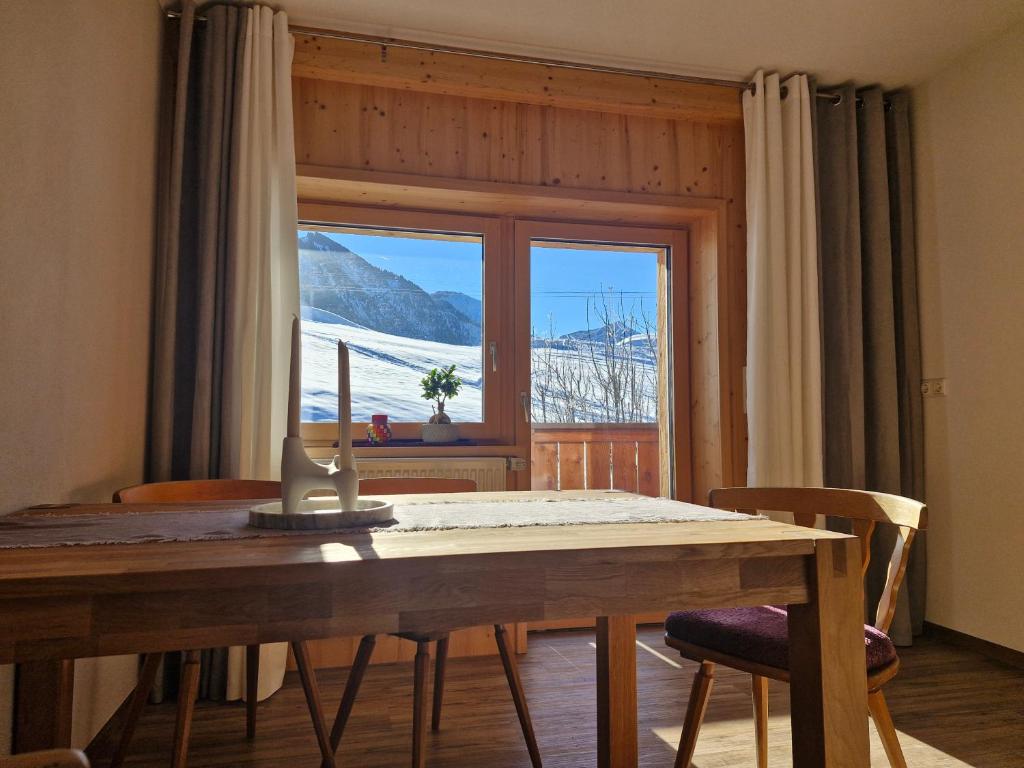 a dining room table with a view of a snowy mountain at Apartment Neunerköpfle in Tannheim