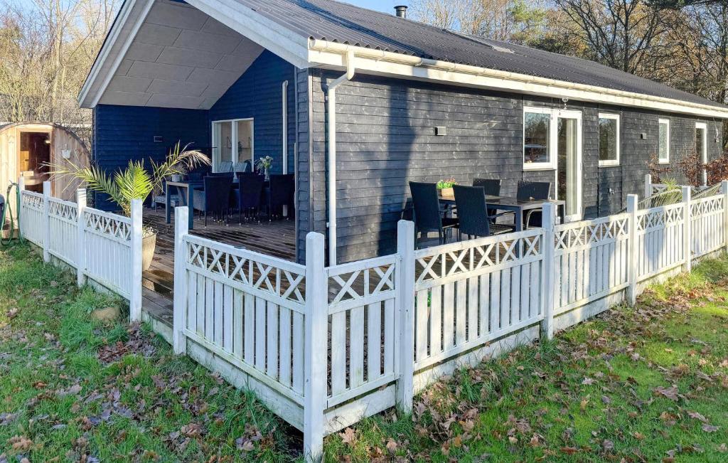 a blue house with a white fence at Beautiful Home In Oksbøl With Sauna in Øster Vrøgum