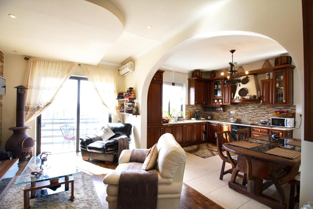 a living room with a table and a kitchen at Sunshine Court in St. Paul's Bay