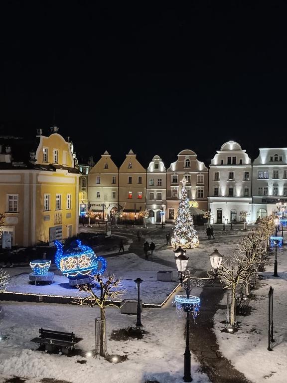 a town with a christmas tree and buildings at night at Apartment Old Town in Bolesławiec