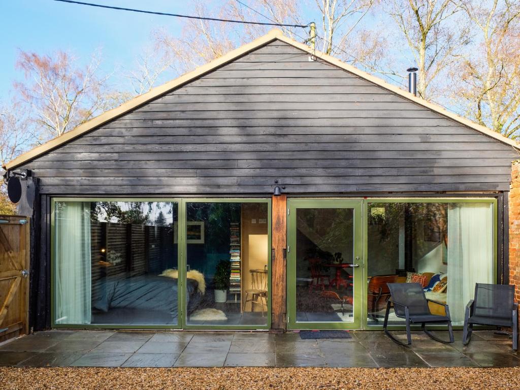 a house with large glass doors and a patio at Sparrows Nest - Uk50109 in Longham