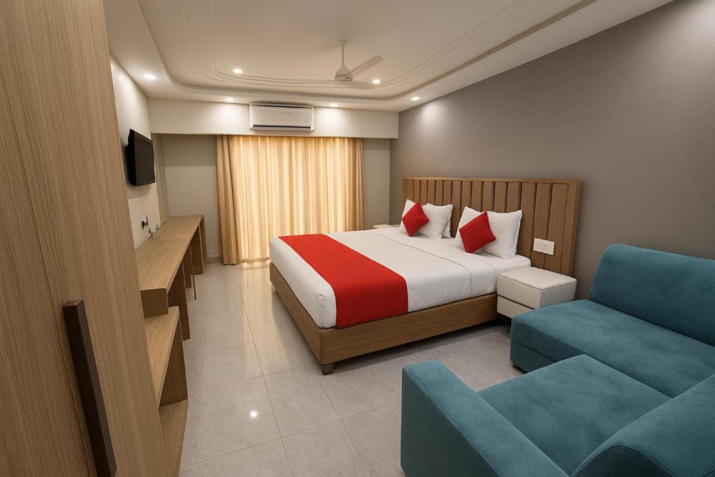 a hotel room with a bed and a blue chair at Hotel Grand Luxury Char Dham in Vrindāvan