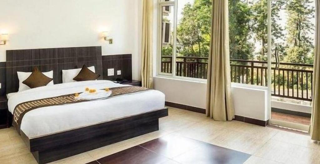 a bedroom with a large bed and large windows at Exotic resort in Gaushala