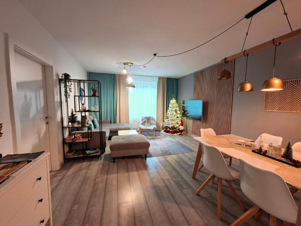 La Vida appartment 1 في كلاغنفورت: غرفة معيشة مع طاولة وغرفة معيشة مع شجرة عيد الميلاد
