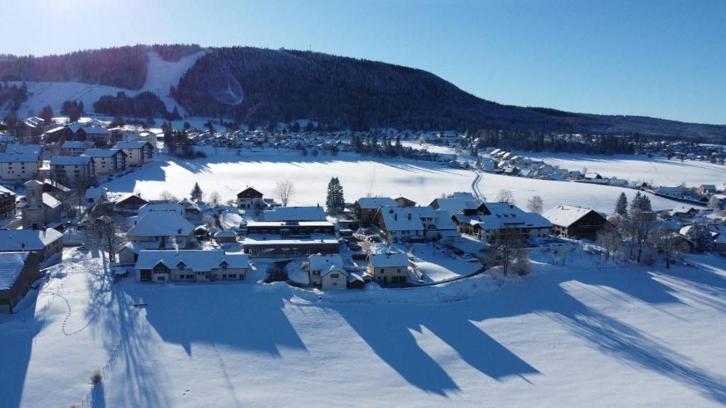 an aerial view of a village covered in snow at Au Doubs Refuge in Métabief