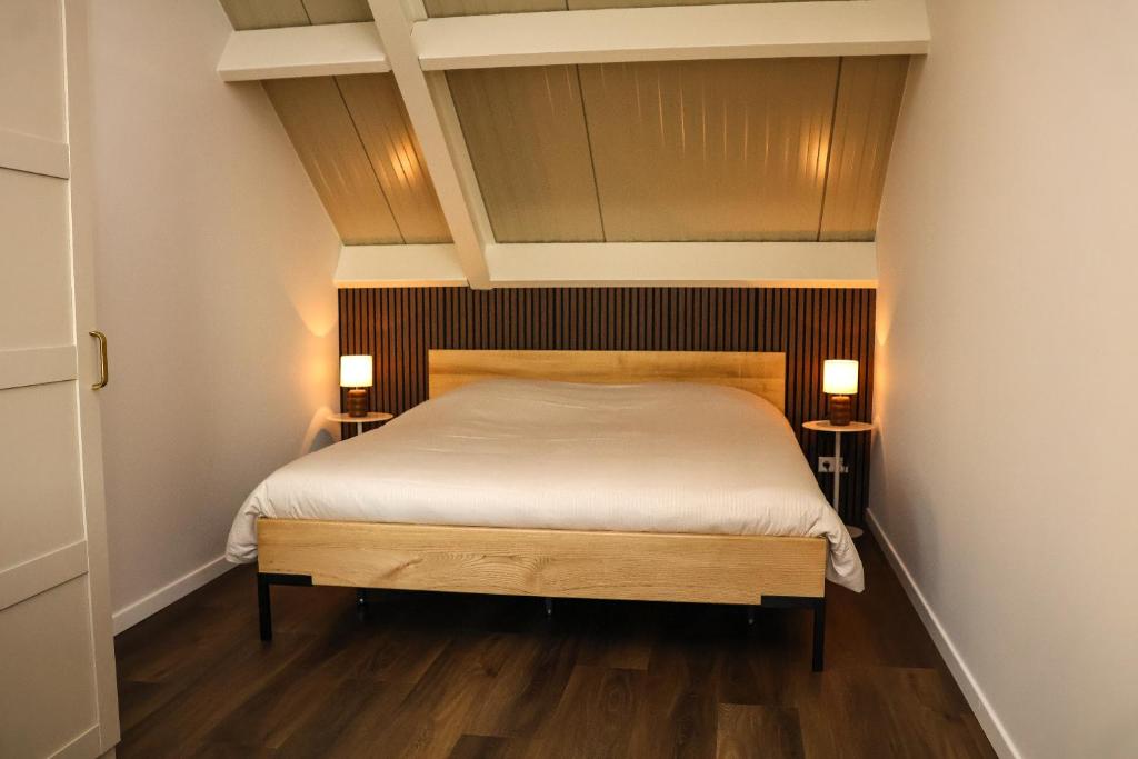 Zicht op Urk في أورك: غرفة نوم بسرير كبير وأرضيات خشبية