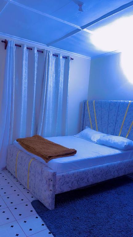 a bed in a room with a blue light at Kash apartments in Diani Beach