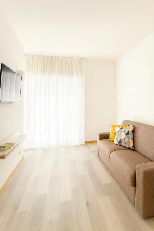 a living room with a couch and a television at Tizi Apartments Porto in Maiori