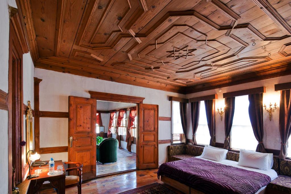 a bedroom with a bed and a wooden ceiling at Gulevi Safranbolu Heritage Hotel in Safranbolu