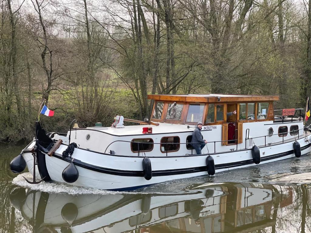 Un barco en un río con un hombre en él en Péniche Sir Lancelot, en Thuin