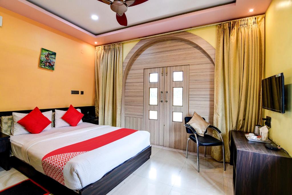 a bedroom with a large bed with red pillows at Hotel O Mahal in Durgāpur
