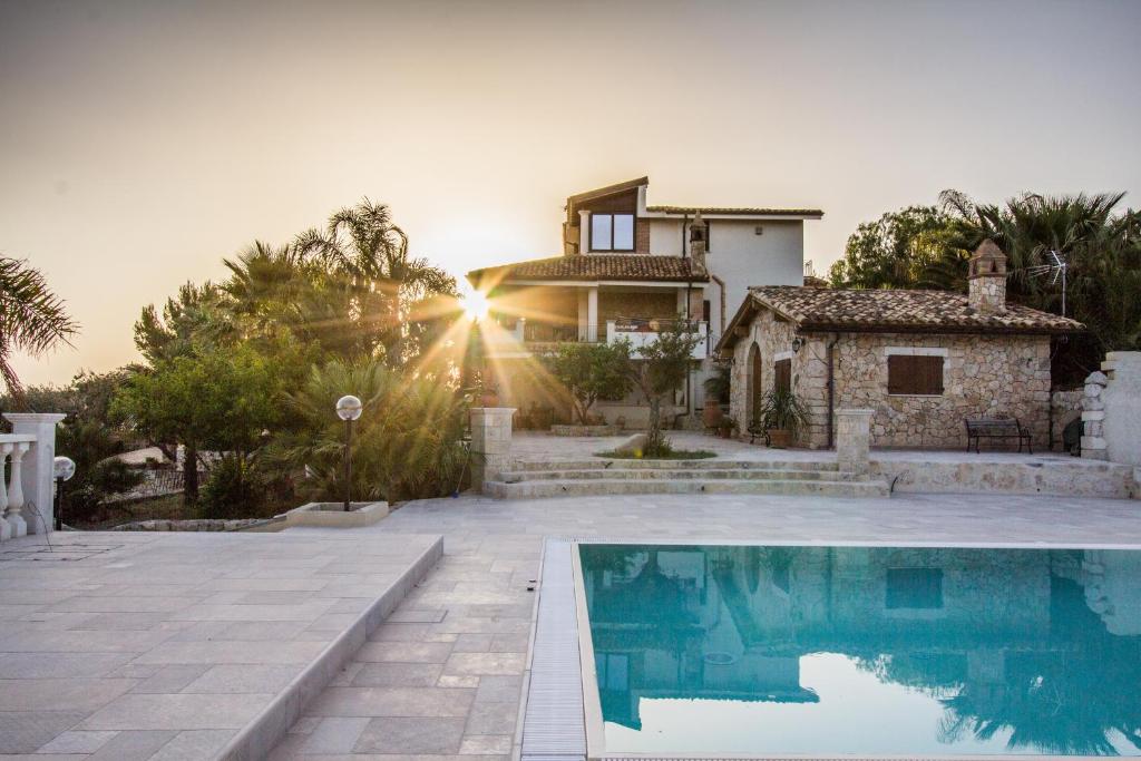 Villa con piscina frente a una casa en Casale Rocca Russa B&B en Villaggio Mosè
