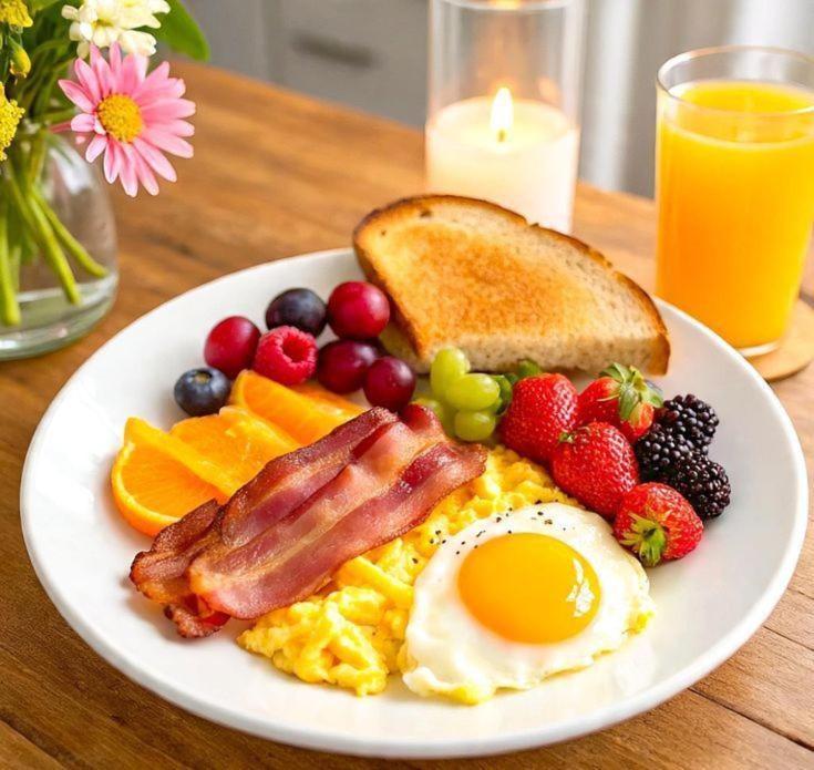 a plate of breakfast food with eggs bacon fruit and toast at Khap Khap Thai Res Hotel 4 in Ho Chi Minh City