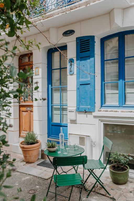 a table and a chair in front of a house at Maison de Pêcheur - La Coquette in Trouville-sur-Mer