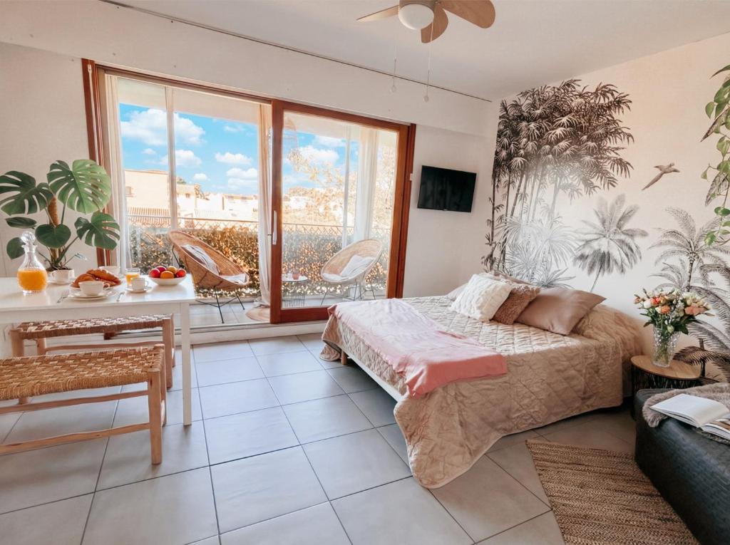 a bedroom with a bed and a large window at Appartement Coup de Coeur avec Parking et Piscine - 131 in Canet-en-Roussillon