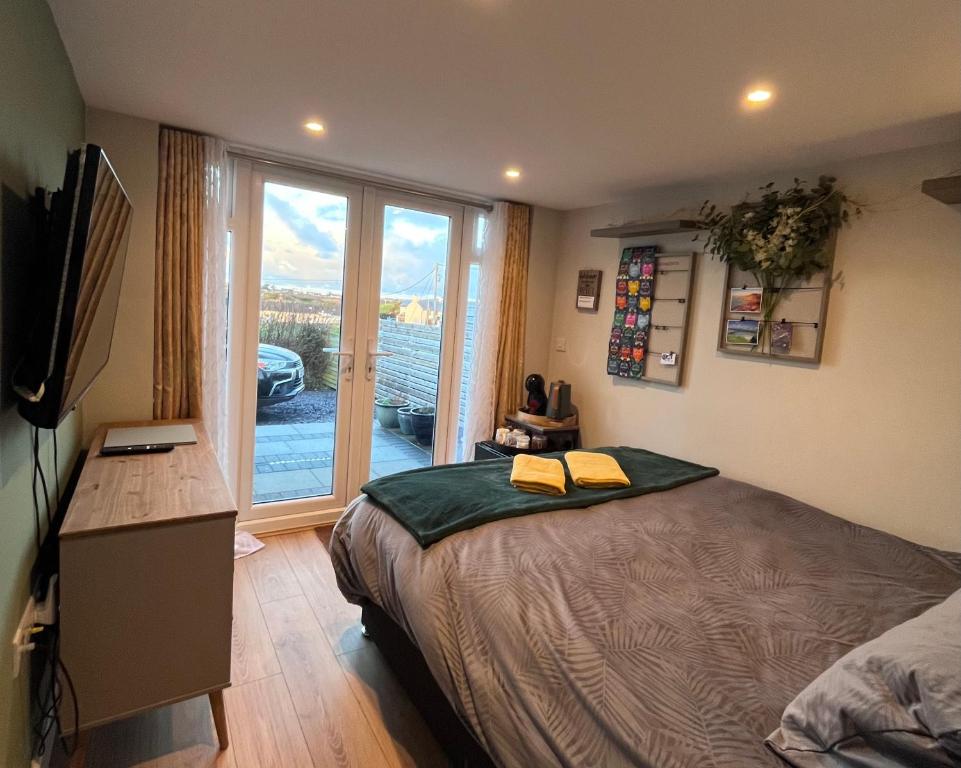 a bedroom with a bed and a large window at Bryn Haul Sunny Hill in Trearddur