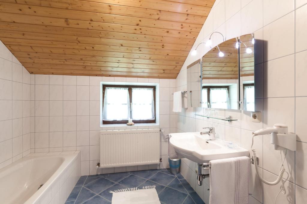 e bagno con vasca, lavandino e vasca. di Chalet a Sankt Gilgen