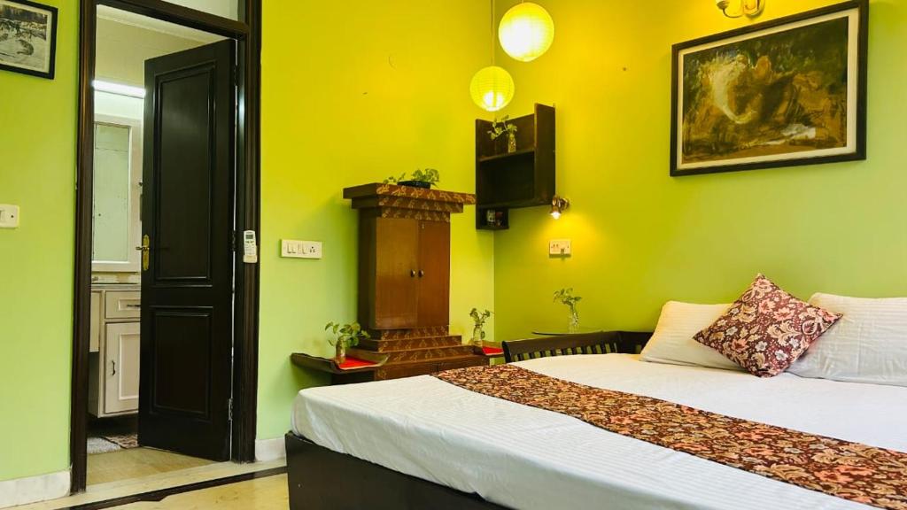 Dr Balis Bliss Homestay Sarvodya Enclave في Jāmb: غرفة بها سريرين وتلفاز على الحائط