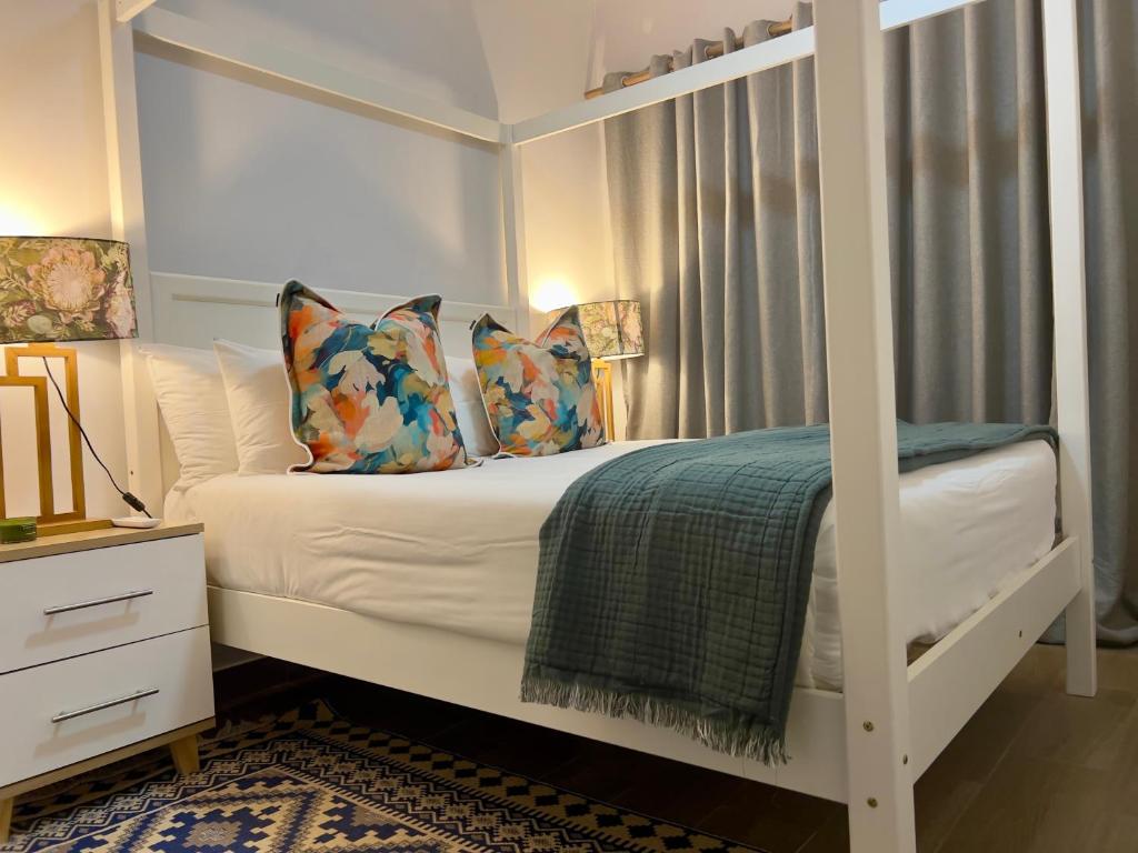 ein Schlafzimmer mit einem weißen Etagenbett mit Kissen in der Unterkunft Sarona LoLa E206 in Gaborone