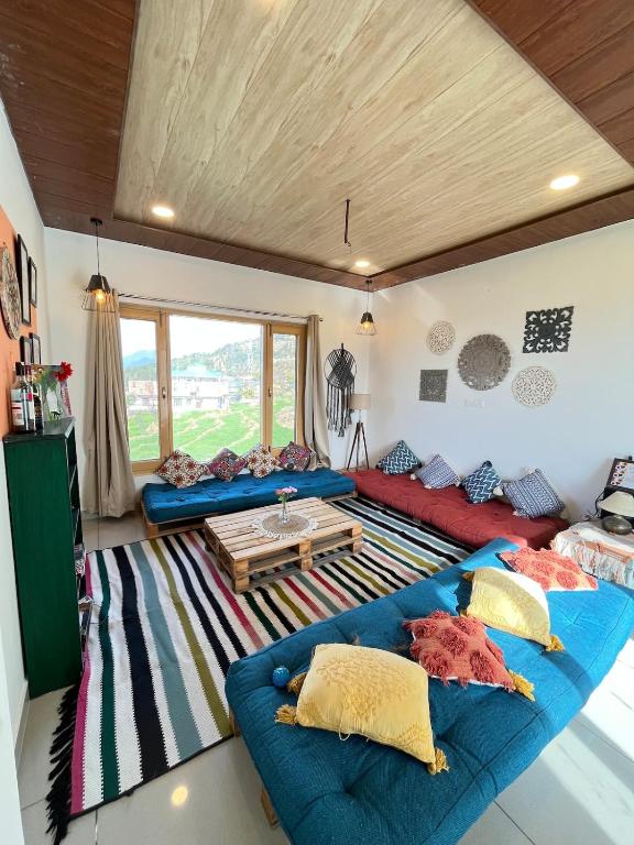 a living room with two blue couches and a table at Luxury KA Villa - BIR in Bīr