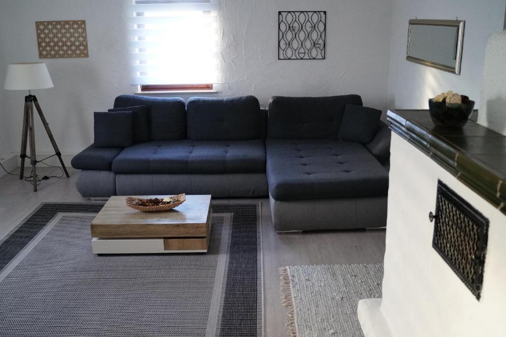 ein Wohnzimmer mit einer blauen Couch und einem Couchtisch in der Unterkunft Ambiente Ferienapartments Julienhöhe in Niederdorf