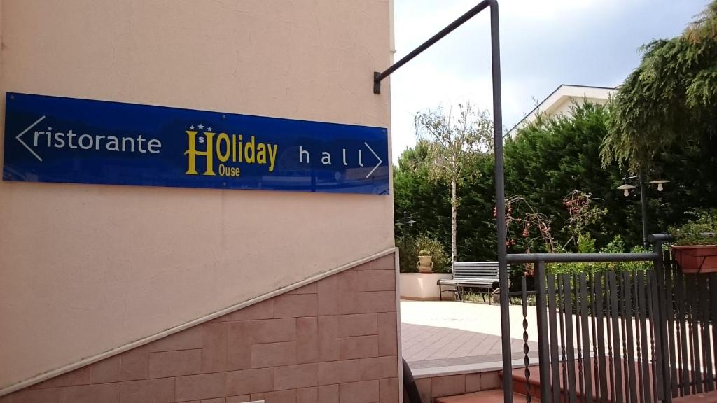 una señal azul en el lateral de un edificio en Hotel Holiday House en San Giovanni Rotondo