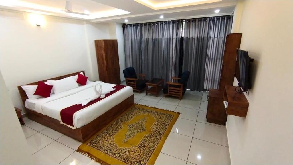 una camera con letto e televisore di Homey Residency vythiri a Padinjarathara